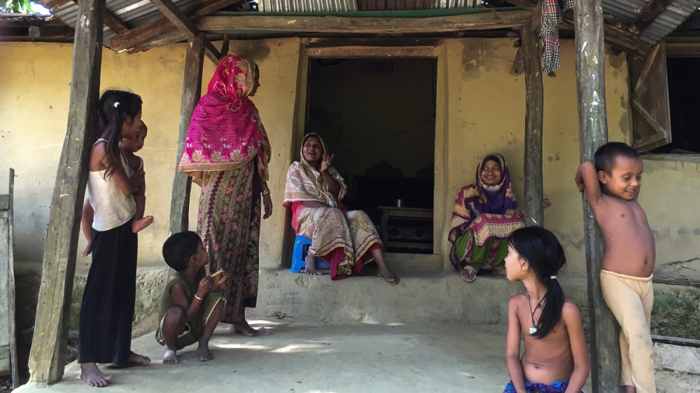 Nur, left and Dilfaraz share a moment, sitting infront of Dilfaraz's house in Kutupalong village [Malavika Vyawahare/Al Jazeera]