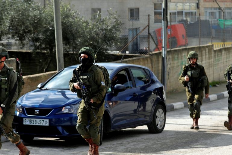 Israeli forces walk during a raid in Ramallah