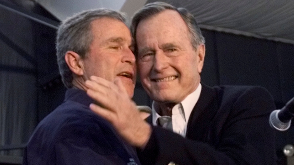 George W Bush and his father George HW Bush during a concert by the Bellamy Brothers in Milford, Connecticut on January 29, 2000 [File: Rick Wilking/Reuters]