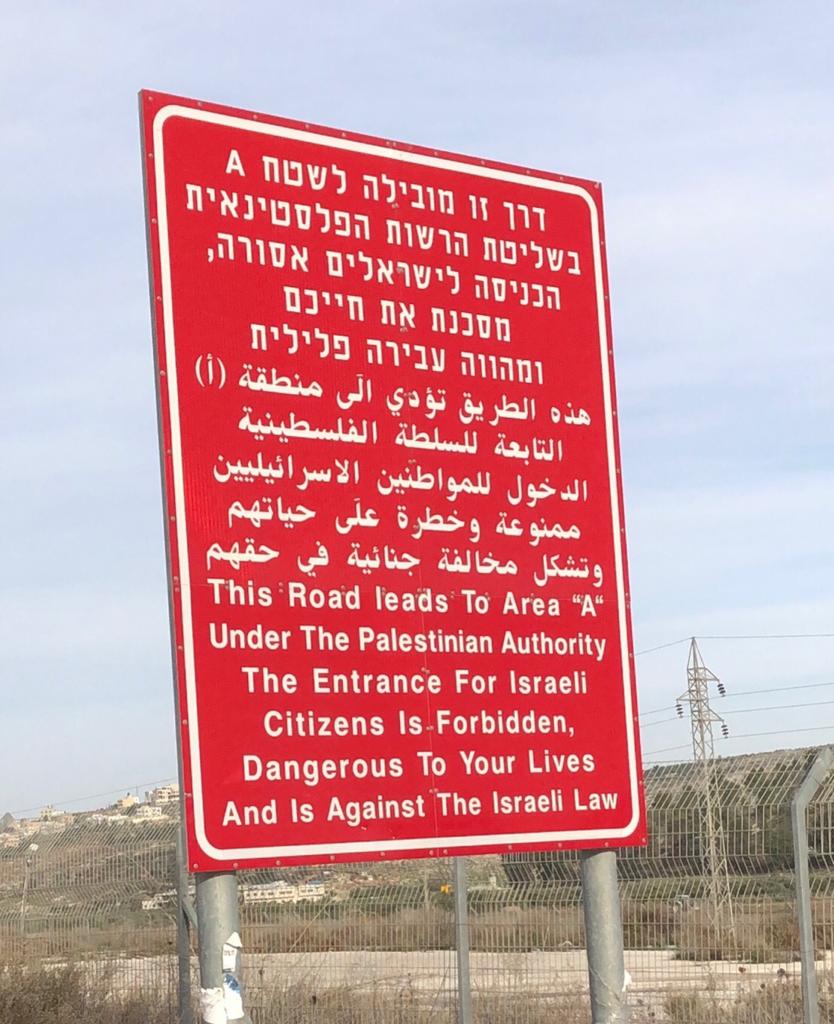 Israeli warning signs are placed at every entrance to 'Area A' in the occupied West Bank [Megan Giovannetti/Al Jazeera]
