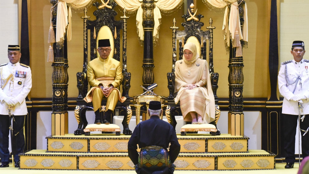 The sixth Sultan of Pahang, Sultan Abdullah Sultan Ahmad Shah, left, takes the oath with his consort on January 15 [Malaysia Ministry of Information Ministry via AP Photo]