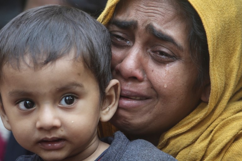 A Rohingya Muslim woman cries as she holds her daughter after they were detained by Border Security Force (BSF) soldiers while crossing the India-Bangladesh border from Bangladesh, at Raimura village