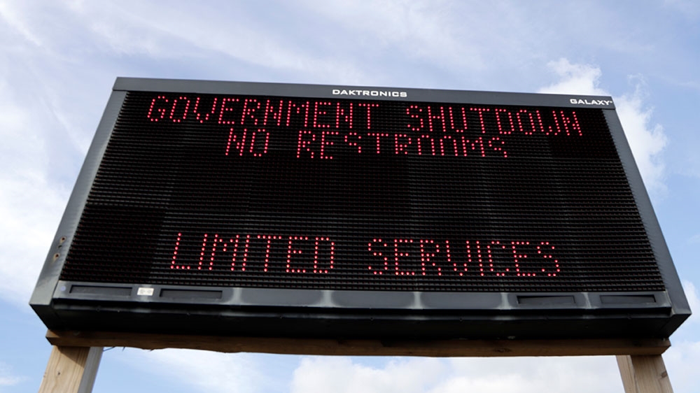 A sign at the entrance to the Gateway National Recreation Area, Sandy Hook, warns visitors of limited services, such as closed restrooms, during the partial government shutdown [Julio Cortez/AP Photo] 