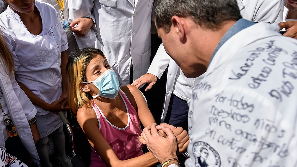 Opposition leader Juan Guaido greets a patient outside the University Hospital of Venezuela's Central University (UCV) in Caracas [Luis Robao/AFP] 