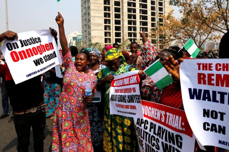 People hold banners during a protest over the suspension of the chief justice of Nigeria (CJN), Walter Onnoghen, in Abuja