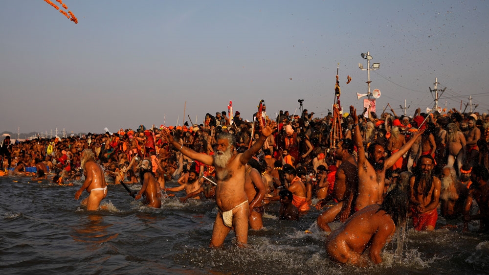Naga Sadhus taking a dip during the first Shahi Snan at the Kumbh [Danish Siddiqui/Reuters]