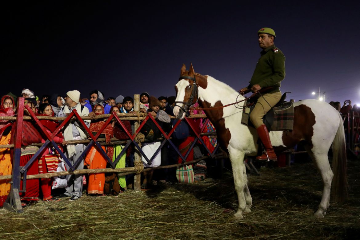 A police officer mounted on his horse maintains order during the first "Shahi Snan" (grand bath) during "Kumbh Mela" or the Pitcher Festival, in Prayagraj, previously known as Allahabad, India, Januar