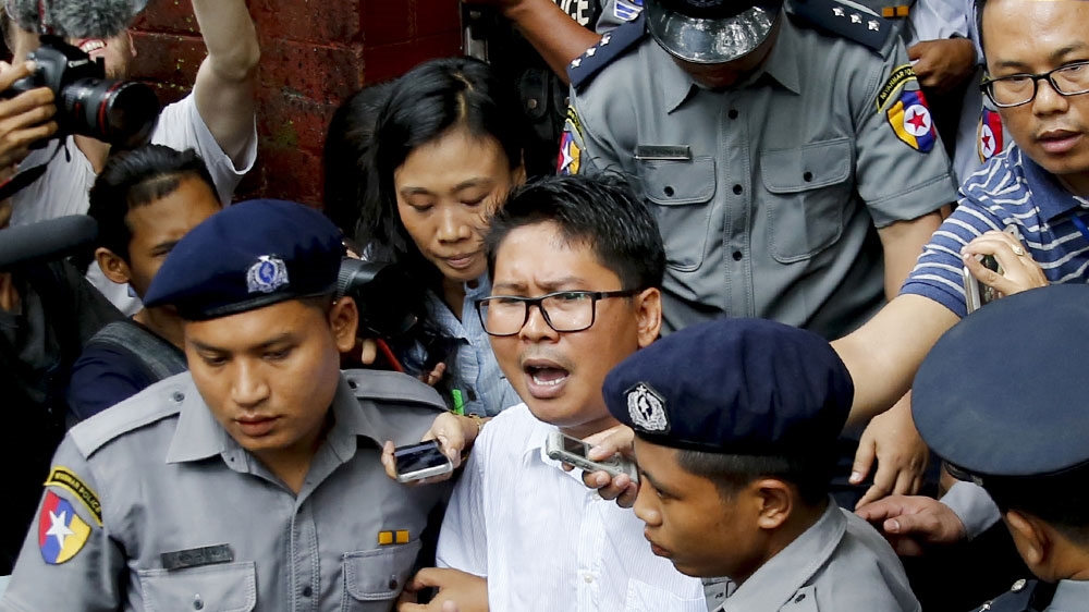 Wa Lone (centre) and his colleague Kyaw Soe Oo were found guilty in September of violating Myanmar's State Secrets Act while working on a story about a massacre of Rohingya [File: Lynn Bo Bo/EPA-EFE]