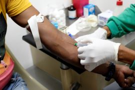 A nurse draws a blood sample for an HIV test