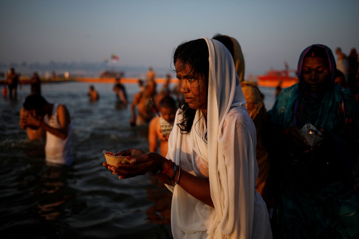 Devotees pray after taking a holy dip at Sangam, the confluence of the Ganges, Yamuna and Saraswati rivers, during "Kumbh Mela", or the Pitcher Festival, in Prayagraj, previously known as Allahabad, I