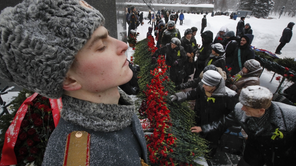 People place flowers to the Motherland Monument at the Piskaryovskoye cemetery [Dmitri Lovetsky/AP Photo]
