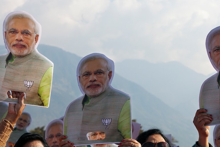 Supporters carry cutouts of the Indian Prime Minister Narendra Modi at a gathering organized to mark the completion of one year of the Bharatiya Janata Party government in Himachal Pradesh, in Dharmsa