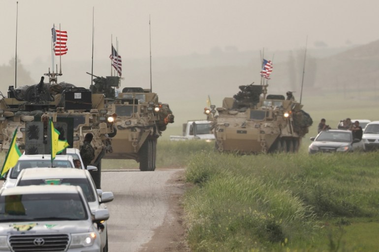 FILE PHOTO: Kurdish fighters from the People''s Protection Units (YPG) head a convoy of U.S military vehicles in the town of Darbasiya next to the Turkish border