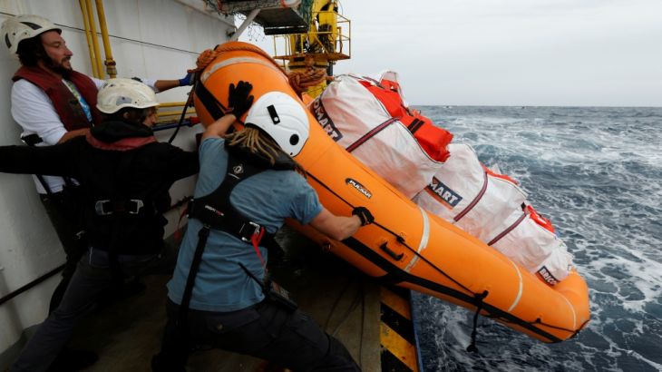Crew members launch a raft carrying life jackets off the migrant search and rescue ship Sea-Watch 3 during a training exercise in the central Mediterranean