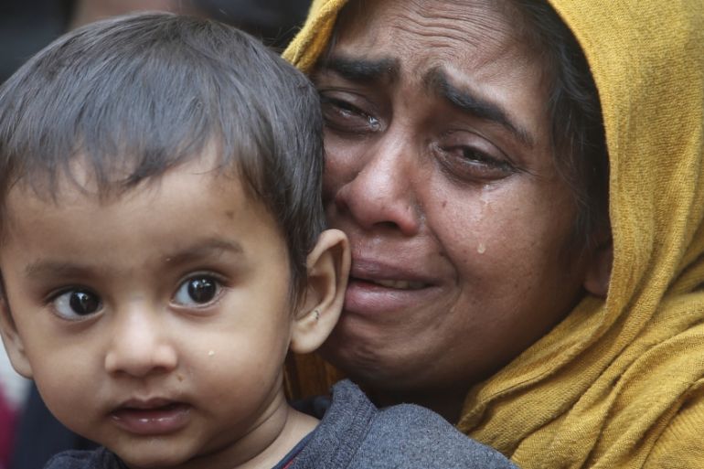 A Rohingya Muslim woman cries as she holds her daughter