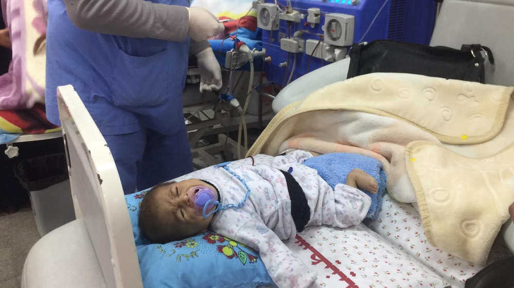 One-and-a-half year old Osama Jundiah has the appearance of a newborn baby due to a kidney problem [Maram Humaid/Al Jazeera]