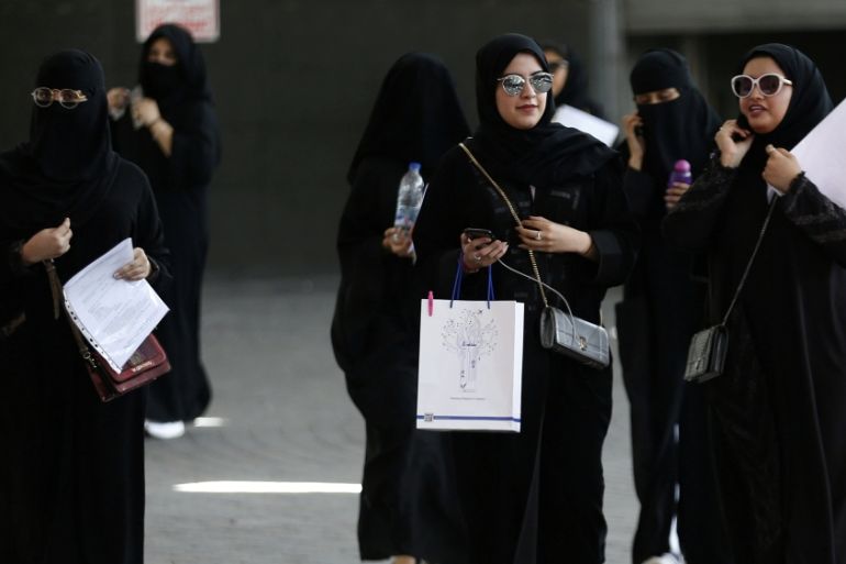 Saudi students walk at the exhibition to guide job seekers at Glowork Women''s Career Fair in Riyadh