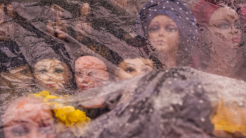 A plastic sheet covers mannequin heads to protect them from the rain [Jose Sarmento Matos/Al Jazeera]