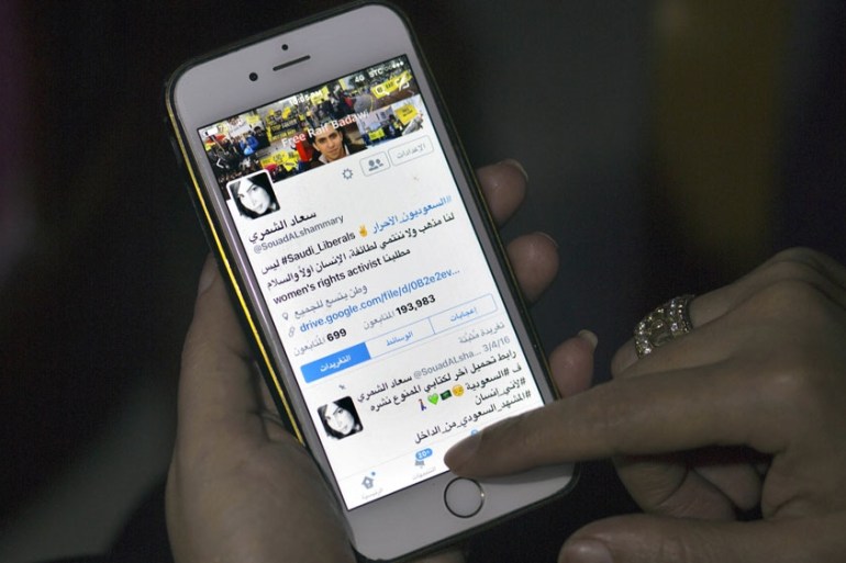 Saudi women''s rights activist Souad al-Shammary looks at her Twitter account on her mobile phone in Jiddah, Saudi Arabia