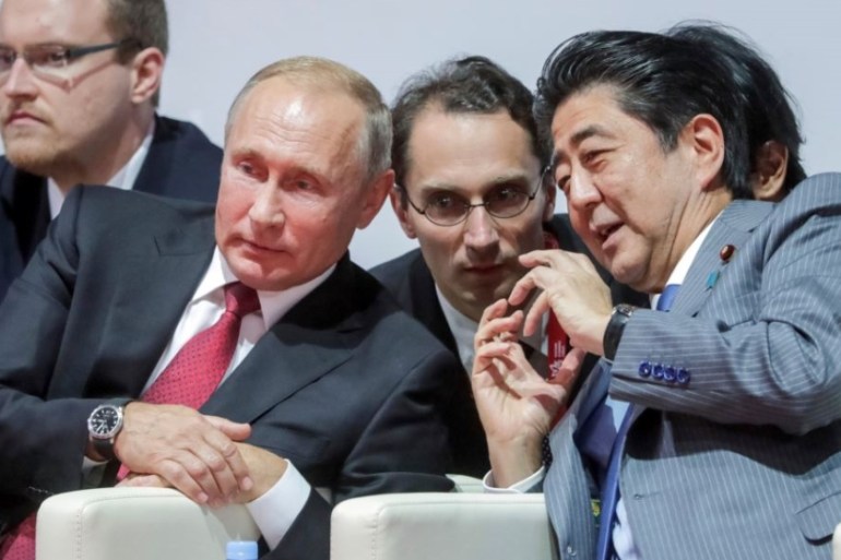 Russian President Vladimir Putin, left, listens to Japanese Prime Minister Shinzo Abe