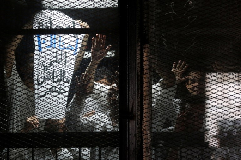 Egyptian photojournalist Mahmoud Abu Zeid (R), also known as "Shawkan", looks on with other journalists behind bars during their trial at a court on the outskirts of Cairo, Egypt May 31, 2016. The ban