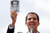 National Assembly President Juan Guaido holds a copy of the Venezuelan constitution during a rally against Nicolas Maduro's government in Caracas on January 23, 2019 [Reuters/Carlos Garcia Rawlins]