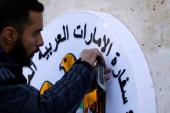 A man works on the United Arab Emirates embassy emblem during its reopening in Damascus, Syria on December 27, 2018 [Omar Sanadiki/Reuters]