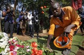 A worker lays flowers in honor of the dead outside the gate of the Dusit Hotel complex which was attacked last week, in Nairobi, Kenya Tuesday, Jan. 22, 2019 [Ben Curtis/AP Photo]