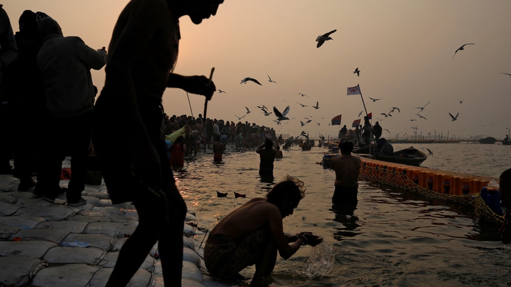 Devotees take a holy dip at the Sangam, the confluence of the Ganges, Yamuna and mythical Saraswati rivers [Danish Siddiqui/Reuters]