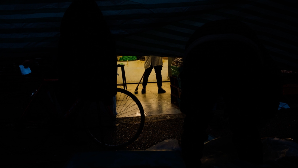 A fishmonger cleans his stall before the market opens [Jose Sarmento Matos/Al Jazeera]