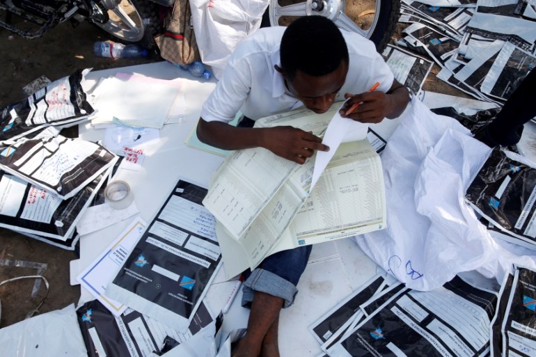 Man examines voting materials at CENI tallying centre in Kinshasa