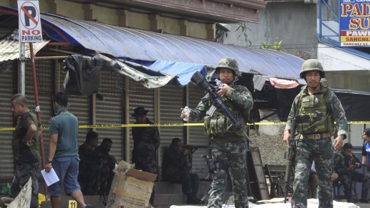 Soldiers attend the scene after two bombs exploded outside a Roman Catholic cathedral in Jolo, the capital of Sulu province in southern Philippines, Sunday, Jan. 27, 2019. Two bombs minutes apart tore