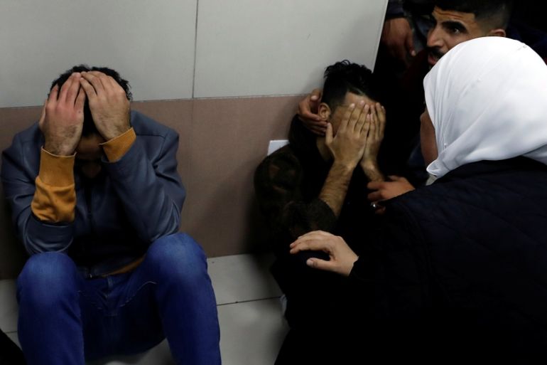 Relatives of Palestinian Hamdy Al-Nasan react as his body is brought into a hospital morgue, in Ramallah, in the Israeli-occupied West Bank