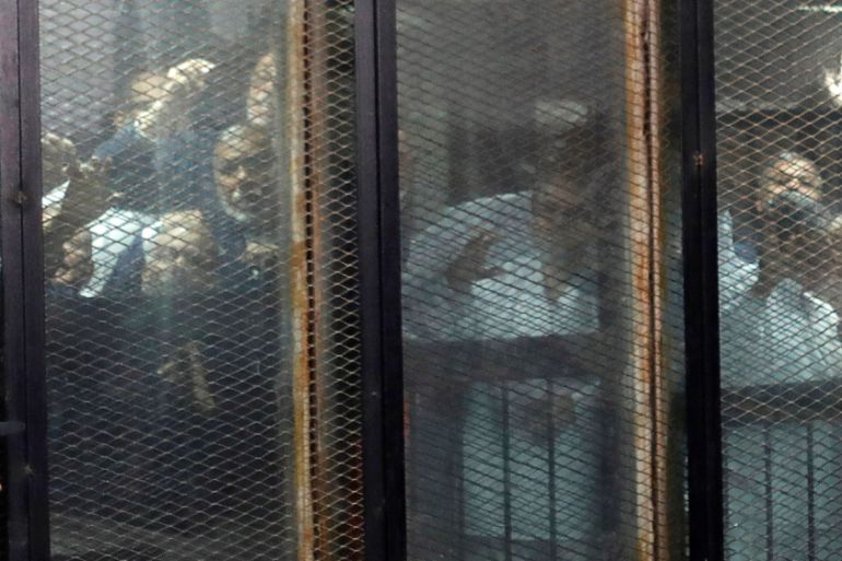 Muslim Brotherhood members are seen behind bars during a court session in Cairo