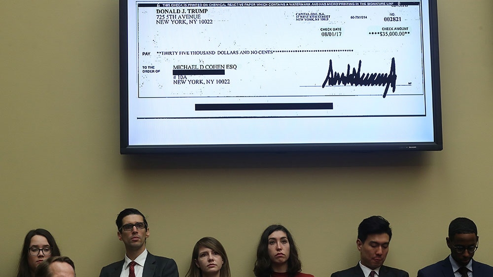 A $35,000 cheque signed by US President Donald Trump to Michael Cohen, his former personal lawyer, is shown on a television monitor at Cohen's hearing on Capitol Hill [Jonathan Ernst/Reuters] 