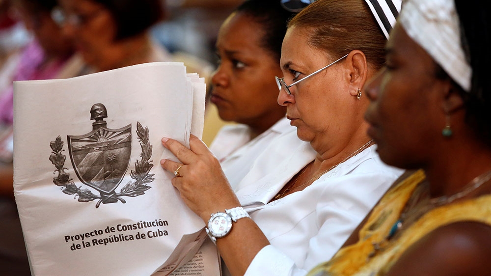 A Cuban nurse holds the draft proposal of changes to the constitution during the beginning of a public political discussion to revamp a Cold War-era constitution [Tomas Bravo/Reuters]