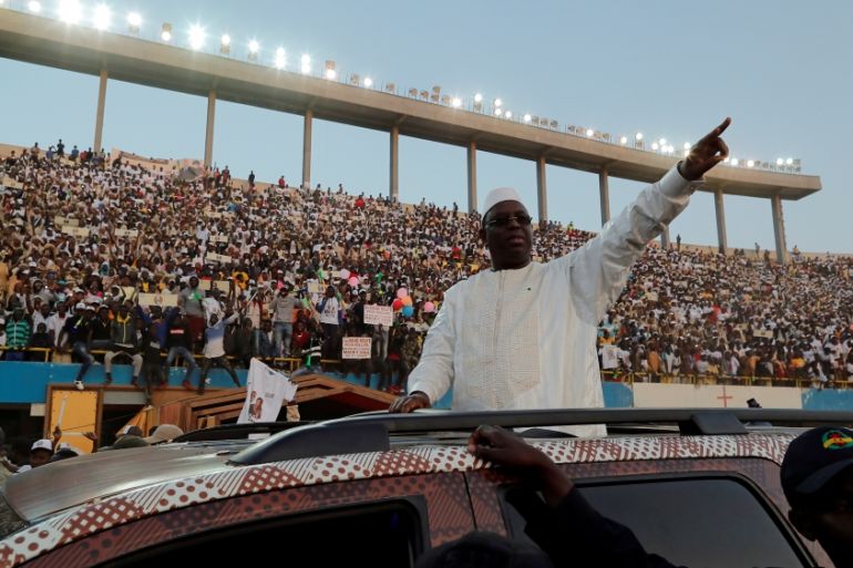 Senegal''s President and candidate for the upcoming presidential elections Macky Sall greets his supporters as he arrives to attend his final campaign rally in Dakar