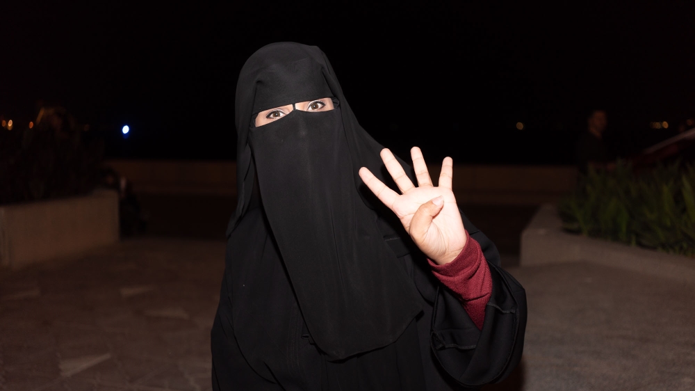 Fatima al-Bureiji poses with four fingers representing the team's 4-0 win over the UAE in the semi-final [Sorin Furcoi/Al Jazeera] 