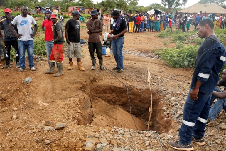 People gather over a shaft as retrieval efforts proceed for trapped illegal gold miners in Kadoma