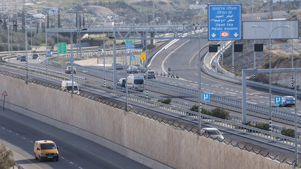 A Palestinian vehicle drives on a newly opened road with a wall segregating Palestinian traffic from the Israeli on Highway 1, near al-Zaayyim village, West Bank on January 23, 2019 [Ahmad Al-Bazz/Activestills/Al Jazeera]