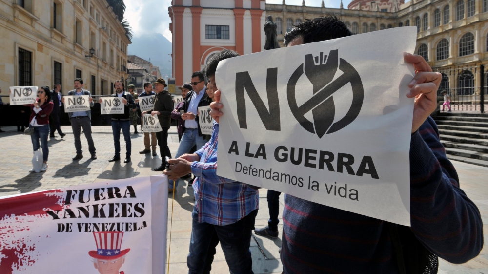 A group of demonstrators takes part in a protest as a meeting of the Lima Group. The placard reads 'No to the war, we defend life' [Carlos Julio Martinez/Reuters] 