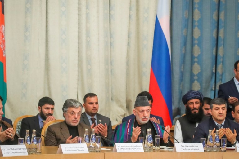 Afghan former President Hamid Karzai and other participants pray during a conference arranged by the Afghan diaspora in Moscow