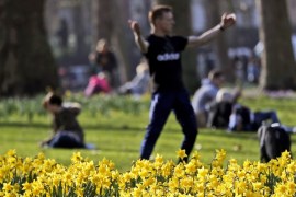 People enjoy their lunch break in a park during a sunny day as daffodils bloom in London, Friday, Feb. 22, 2019