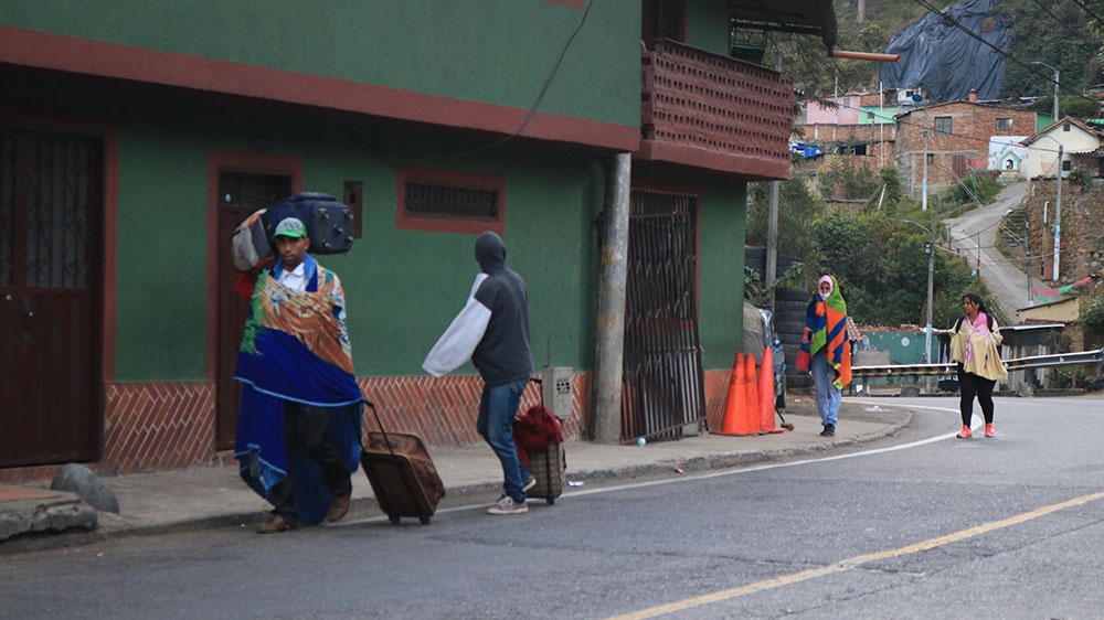 Venezuelans walk, carrying the little belongings took from their homes when they fled [Dylan Baddour/Al Jazeera]