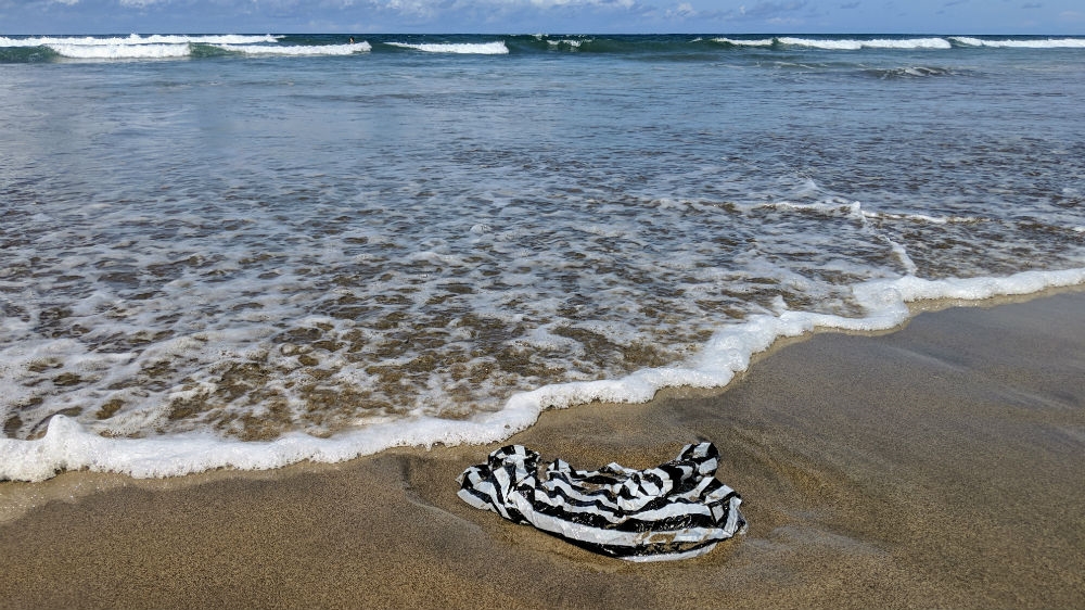 A plastic bag washed up on the shoreline of a beach on Bali's southwest coast. [Kate Walton/Al Jazeera]. 