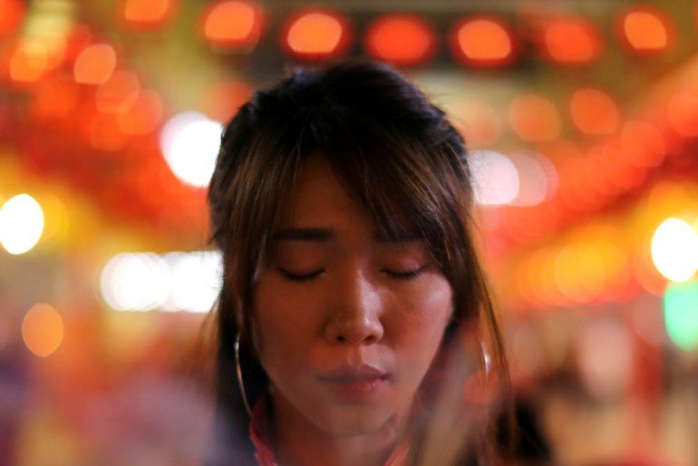 A woman lights incense while praying in a Chinese temple during the celebration of the Lunar New Year in Chinatown in Bangkok, Thailand February 4, 2019. REUTERS/Jorge Silva TPX IMAGES OF THE DAY