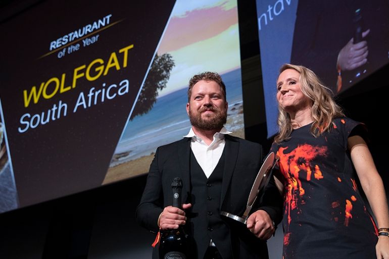 Chef Kobus van der Merwe (L) receives the best Restaurant of the year award for his restaurant "Wolfgat" in South Africa during the inaugural World Restaurant Awards on February 18, 2019 at the Palais