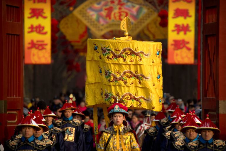 A performer dressed as an emperor, center, participates in a Qing Dynasty ceremony in which emperors prayed for good harvest and fortune at a temple fair in Ditan Park in Beijing, Tuesday, Feb. 5, 201