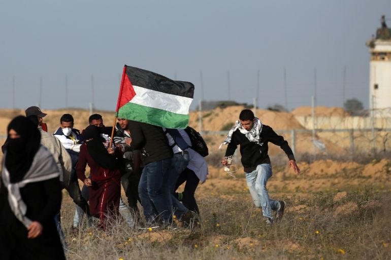 Medics and demonstrators evacuate a wounded Palestinian during a protest at the Israel-Gaza border fence, in the southern Gaza Strip
