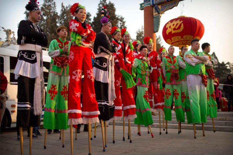 Performers on stilts watch a drum performance at Ditan Park in Beijing, Tuesday, Feb. 5, 2019. Chinese people are celebrating the first day of the Lunar New Year on Tuesday, the Year of the Pig on the
